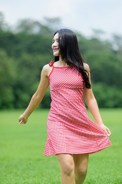 Woman in Red Dress Enjoying Nature in Beautiful Flower Garden