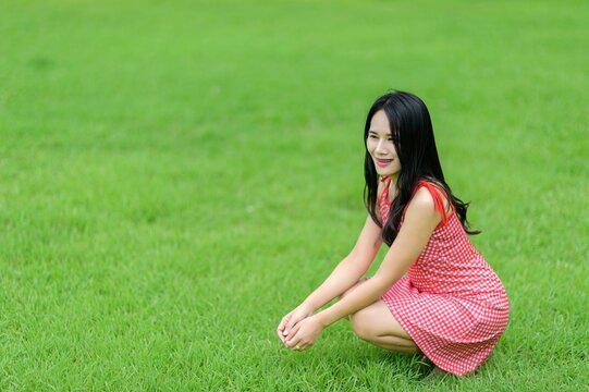 Woman in Red Dress Enjoying Nature in a Beautiful Flower Garden