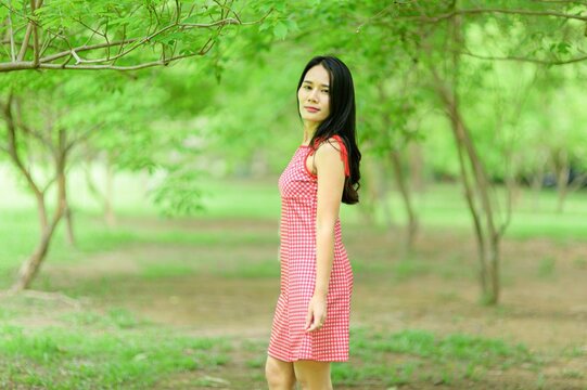 Woman in Red Dress Enjoys Natural Beauty in Flower Garden Setting