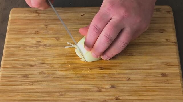 Chopping onions step by step in a kitchen with a wooden cutting board in the afternoon