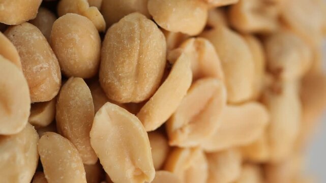 Roasted peanuts spinning in extreme closeup view showing detailed texture and golden color.