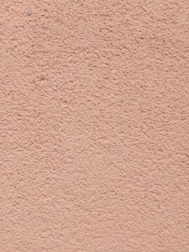 Peach colored rough plaster wall texture background