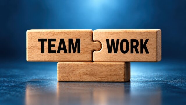 Two connecting wooden puzzle pieces with teamwork text on blue background represents perfect collaboration.