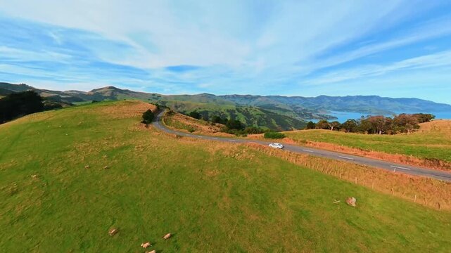 Aerial shot of New Zealand, a car driving on a mountainside road, Akaroa