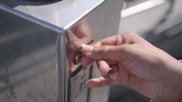 Person Inserting Coin into Metal Parking Meter