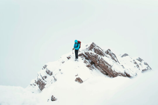 Mountaineer using an ice axe to climb Forcan Ridge in Glen Shiel, Scotland