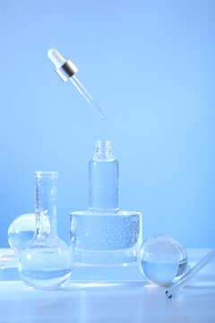 Bottles and droppers sit on a blue surface with bubbles