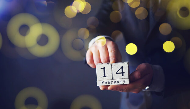 Hand holding wood cubes with 14 February date calendar. concept of Saint Valentine's.