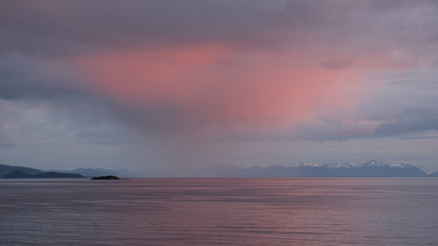 Breathtaking Alaska mountain glacier range view seen from outdoor deck of cruise ship liner sailing the Inside Passage transit with spectacular landscape scenery during sunset