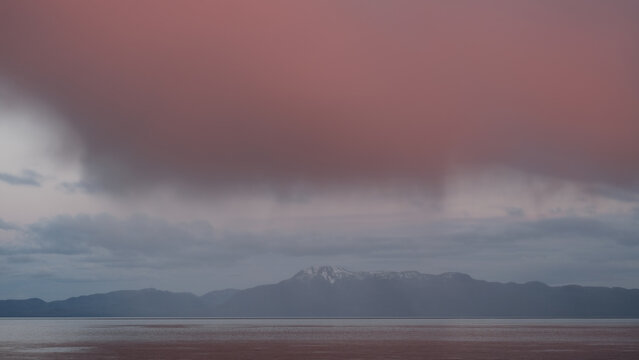 Breathtaking Alaska mountain glacier range view seen from outdoor deck of cruise ship liner sailing the Inside Passage transit with spectacular landscape scenery during sunset