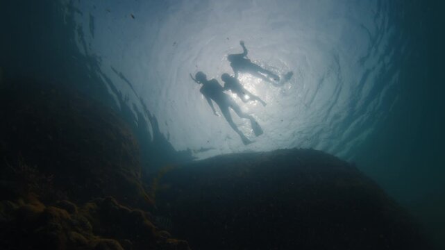 Underwater view of the family with kids snorkeling in the sea