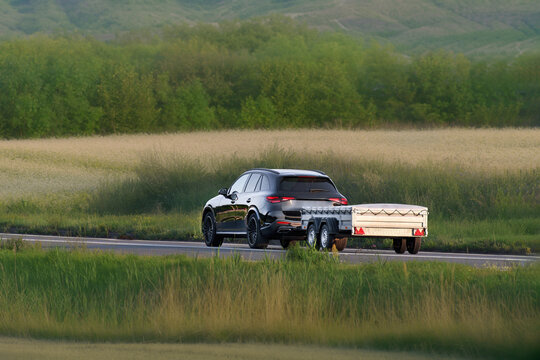 Car pulling a sturdy utility trailer on highway