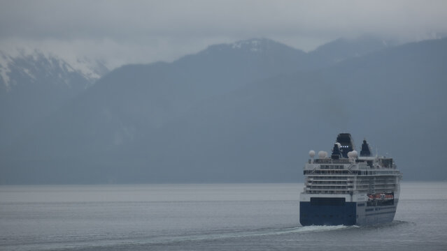 Breathtaking mountain glacier range view with luxury cruiseship cruise ship liner Summit sailing in front of Alaska mountains departure from Hoonah, Icy Strait Point with spectacular landscape scenery