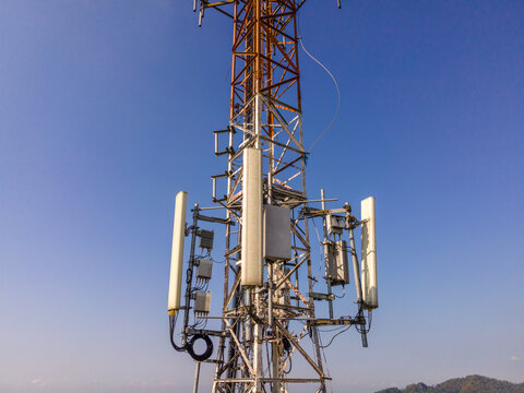 Aerial Scenery of Multiple Radio Masts and Antenna Equipment Installed on a Large Telecommunication Tower Under a Clear Morning Sky. Communication Technology and Network Equipment Viewed from Above.