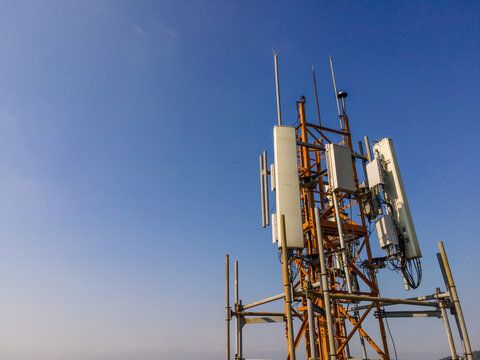 Aerial Scenery of Multiple Radio Masts and Antenna Equipment Installed on a Large Telecommunication Tower Under a Clear Morning Sky. Communication Technology and Network Equipment Viewed from Above.