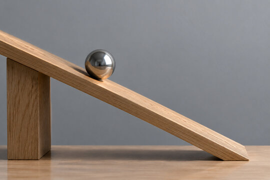 Steel ball on tilted wooden board, inclination and gravity balance concept