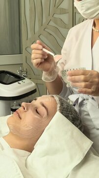 Teenage girl receives a professional facial mask treatment in a beauty salon, youthful skincare, gentle cleansing, hydration and healthy complexion care.