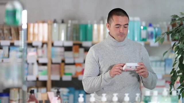 Male buyer buys paracetamol medicine at a pharmacy . High quality 4k footage