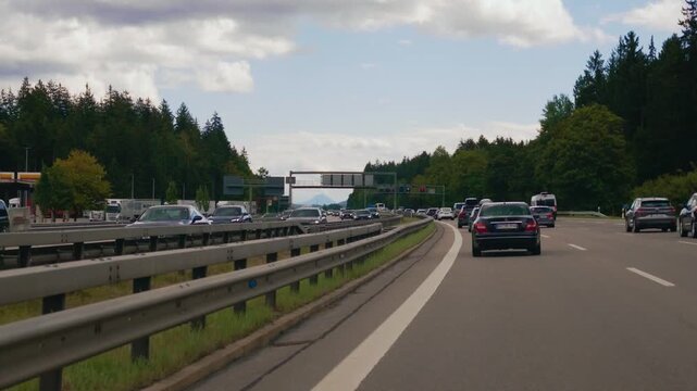 Driving through heavy traffic on German Autobahn A8 in Bavaria towards Salzburg with Alps in distance