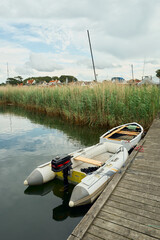 Fototapeta premium Small boats tied to a wooden dock on a quiet river