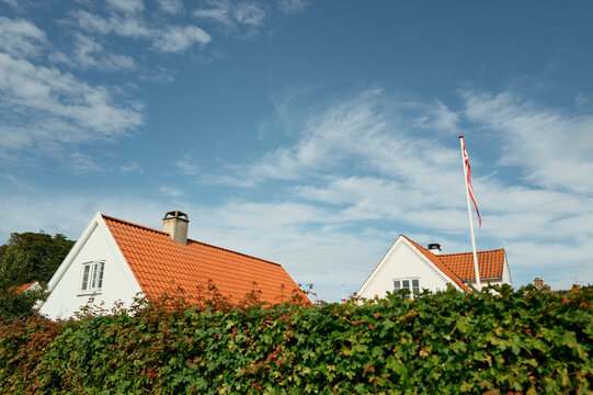 Red tile roofs and Danish flag against blue sky