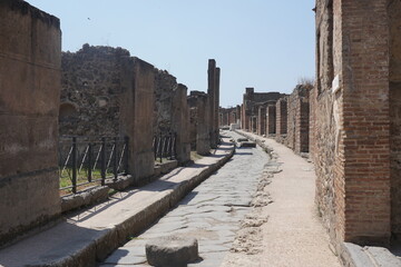 Obraz premium Ancient cobblestone street through the ruins of Pompeii