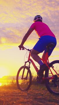 A senior adult enjoys a recreational cycling pursuit during sunset, embracing an active lifestyle in a serene environment. The scenic backdrop enhances the sense of adventure and tranquility.