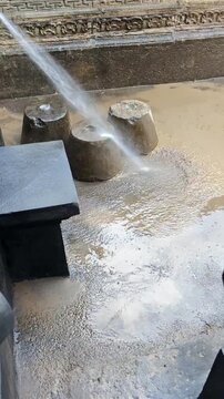 Pressure washing concrete floor with water jet stream cleaning dirt