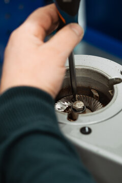 Service worker disassembles professional coffee grinder for maintenance and repair