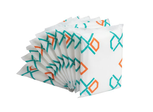 A stack of white rectangular hygiene pads with a geometric teal and orange pattern isolated on a solid black background, for product display isolated on a transparent background