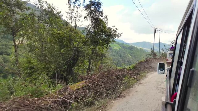 Moving Jeep on Narrow Mountain Road Overlooking Deep Green Valley in India