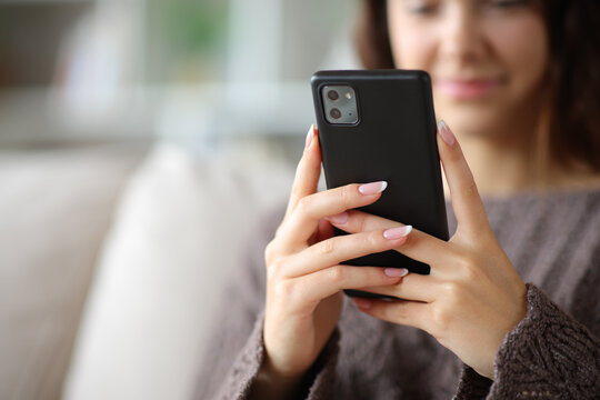 Woman hands holding and using smart phone at home