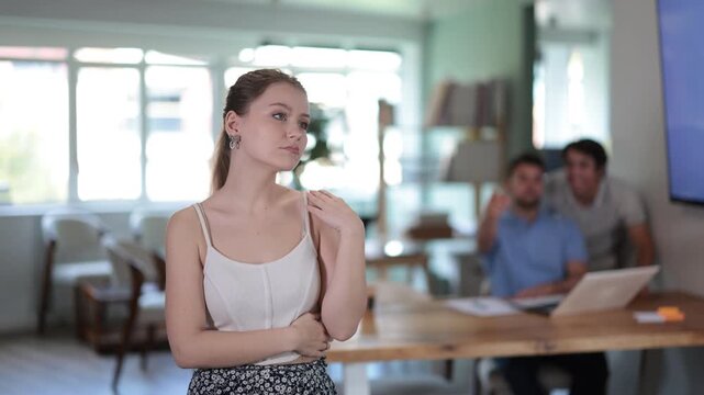 Upset girl suffering from isolation while facing corporate bullying situation during workday in office . High quality 4k footage