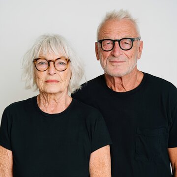 Senior couple wearing glasses against white background