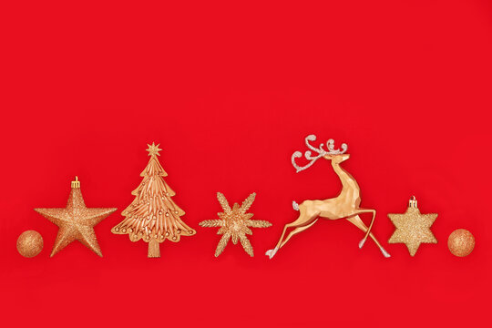 Festive gold glittering Christmas decorations, reindeer, star, tree, snowflake ball shapes. Xmas decorative minimal banner style Xmas design on red background.