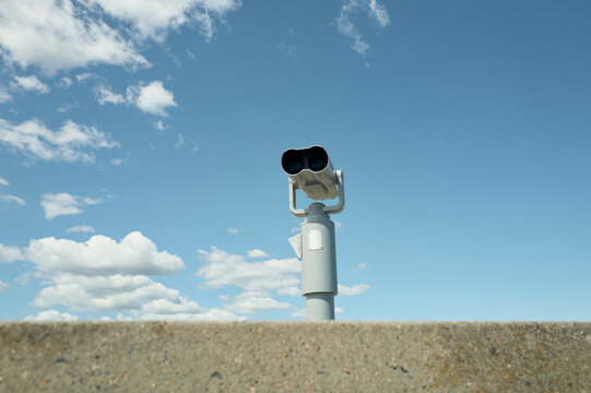 Observation tower binoculars against a blue sky