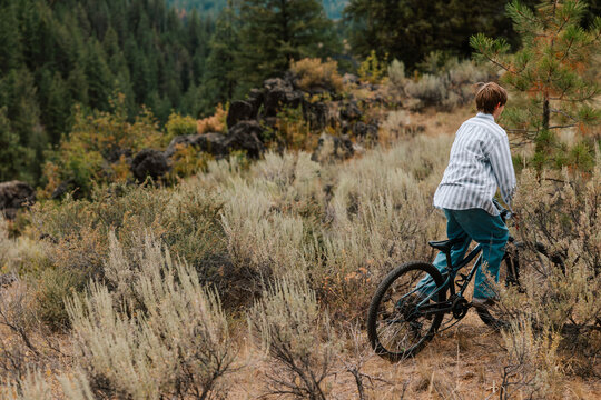 A young boy explores a hillside on his bicycle