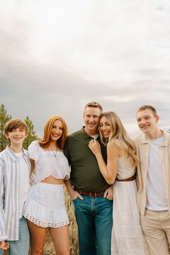 Happy family of five smiling together for an outdoor portrait