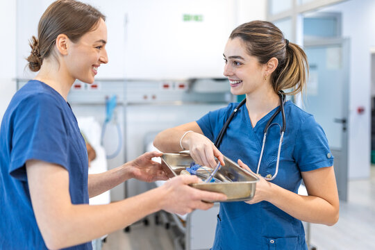 Doctors holding medical instruments tray. Female medical professionals talking and smiling in hospital room, Healthcare and medicine concept, Nurses sharing equipment during shift in clinic ward.