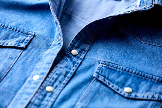 Close up of blue denim shirt with buttons. Soft focus.