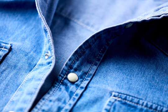 Close up of blue denim shirt with buttons. Soft focus.