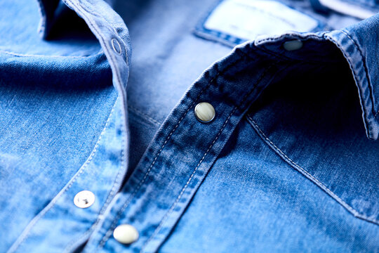 Close up of blue denim shirt with buttons. Soft focus.