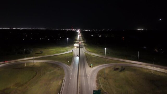 Night drone aerial ascending while facing east over the South Perimeter Highway and Pembina Highway cloverleaf overpass in Winnipeg, Manitoba, Canada.