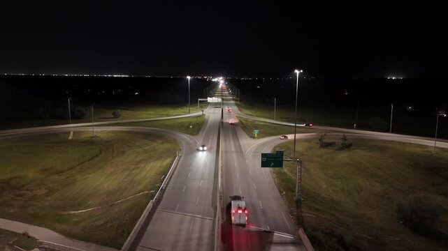 Night drone aerial facing east over the South Perimeter Highway and Pembina Highway cloverleaf overpass showing road illumination in Winnipeg, Manitoba, Canada.