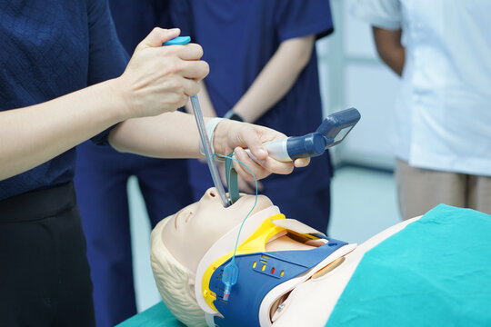 Demonstration of emergency airway management and cervical spine stabilization using a hard collar,Medical simulation training for endotracheal intubation on a mannequin.