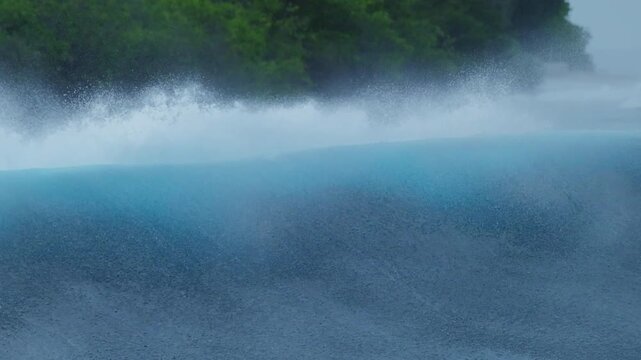 Back view of the ocean wave rolling and breaking on the surf spot in the Maldives