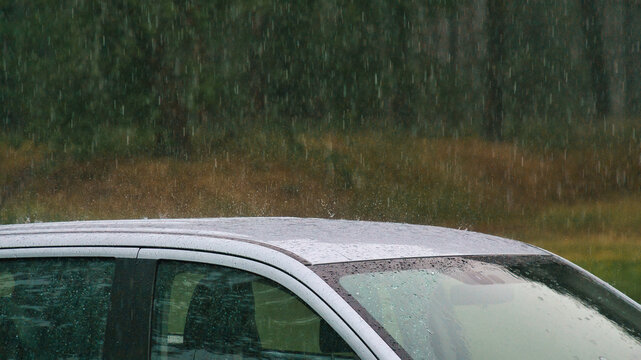 Heavy Rain Pelting the Roof of a Silver Car.