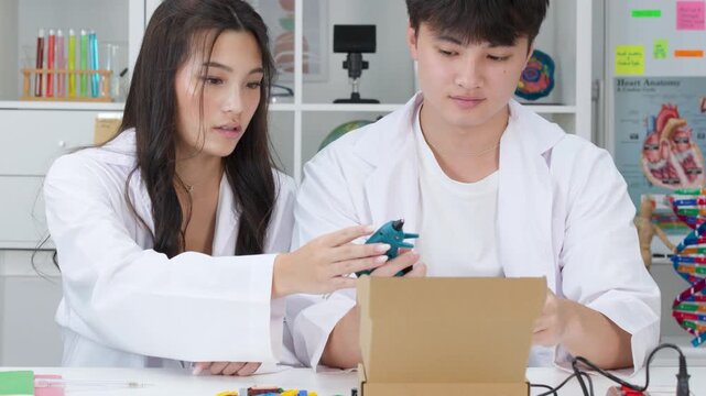Teenage Students in Lab Coats Conducting Science Experiment with Cardboard Box