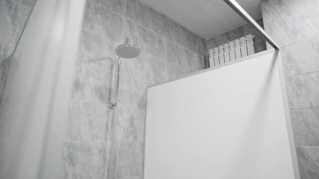 White partions separate individual showers in school shower room. Private and comfortable space for washing after physical activities