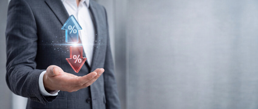 Businessman showing upward and downward arrows with percentage symbols representing interest rate fluctuations, economic growth, inflation, financial investment trends, and stock market volatility.